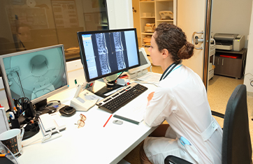 Image of healthcare worker looking at a workstation to illustrate healthcare application monitoring is essential for healthcare professionals to deliver patient care