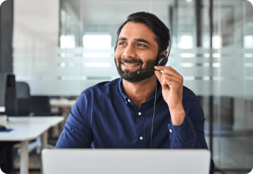 Man with headset smiling at laptop